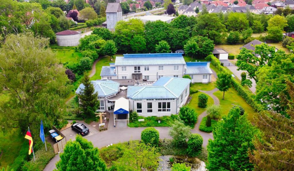 eine Luftansicht eines großen weißen Hauses mit blauem Dach in der Unterkunft Seminar- und Urlaubshotel Schulz in Bergen
