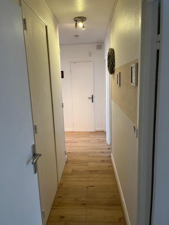 a hallway with a white door and a wooden floor at Chambre d hote au calme in Brétigny-sur-Orge
