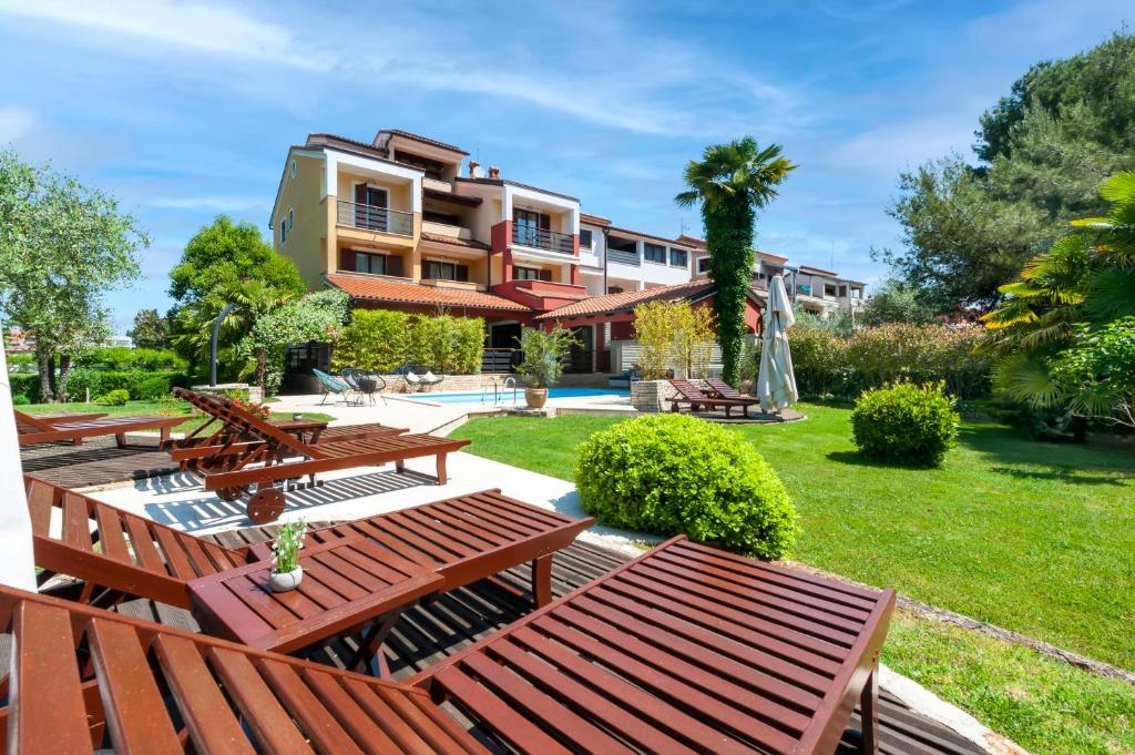 a resort with picnic tables and a lawn at Apartments Villa Rossella 1 in Rovinj