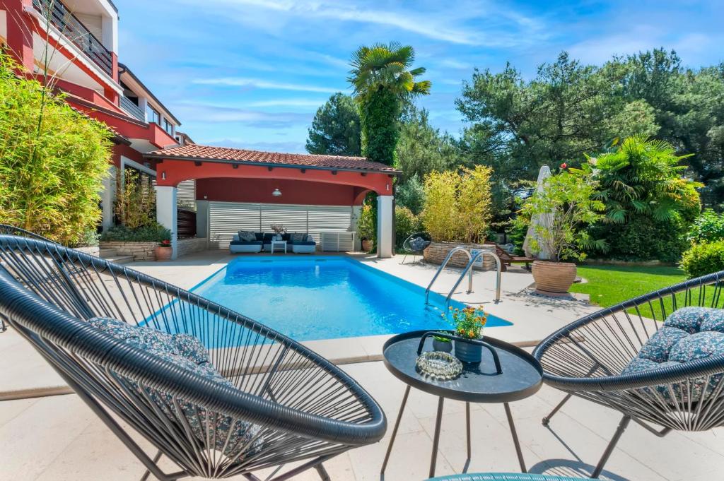 a patio with two chairs and a pool at Apartments with Pool Villa Rossella 1 in Rovinj