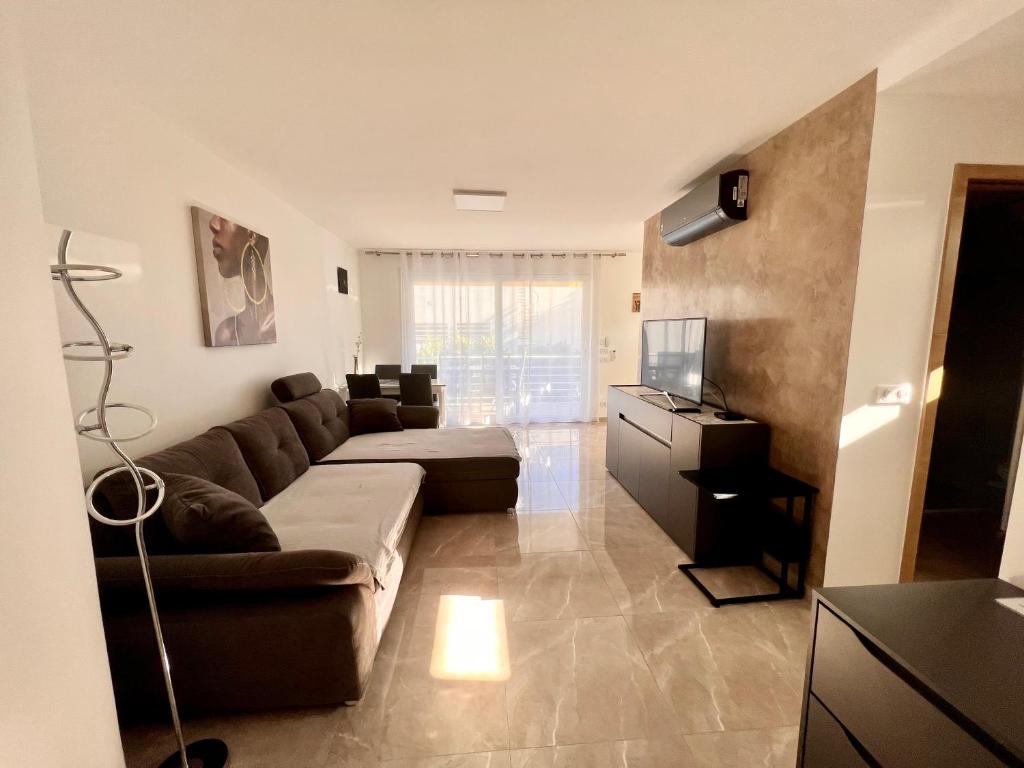 un salon avec un canapé et une télévision dans l'établissement APPART/PALM BEACH/ CANNES, à Cannes