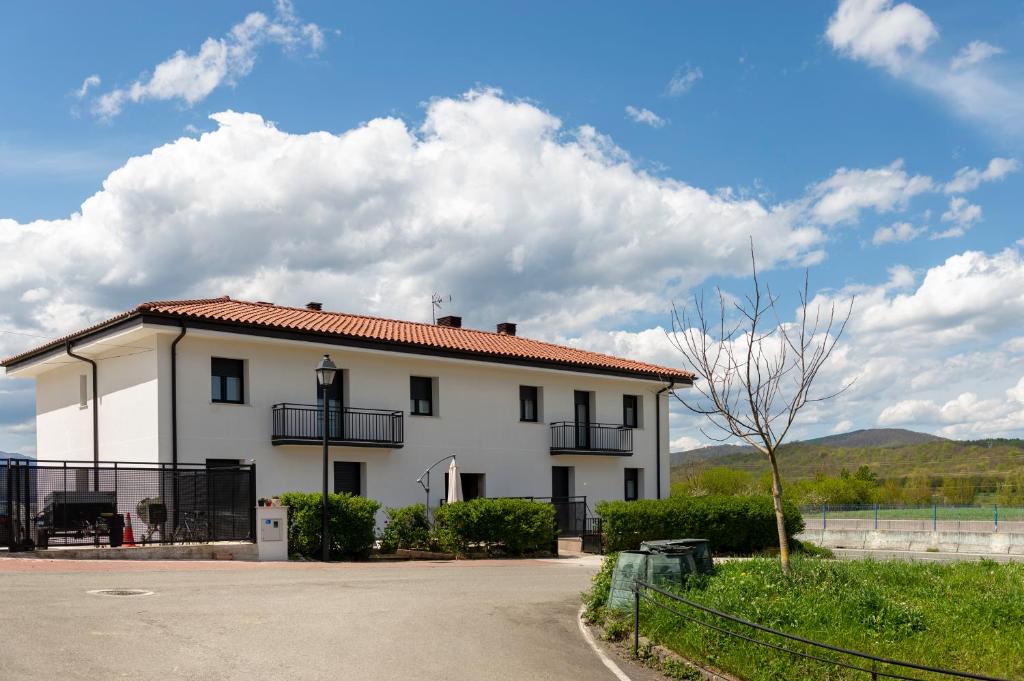 Casa blanca con techo rojo en Apartamentos Herri Ondo URBASA INVERNAL, en Iturmendi