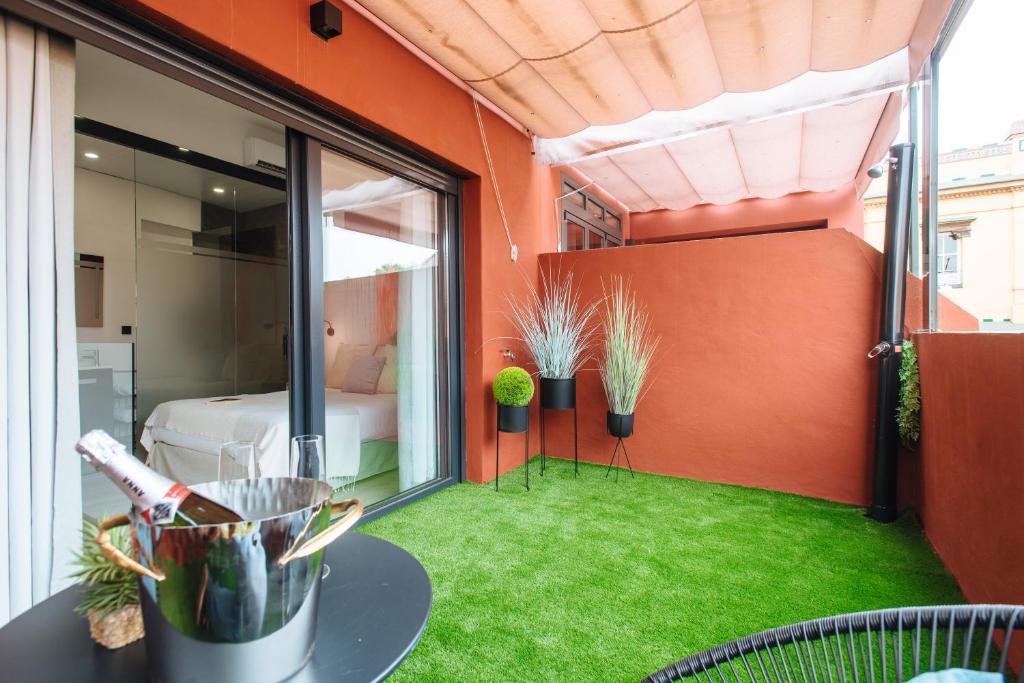 Pokój z balkonem z zielonym trawnikiem. w obiekcie Guardamino Dúplex Suite Apartment w Sewilli