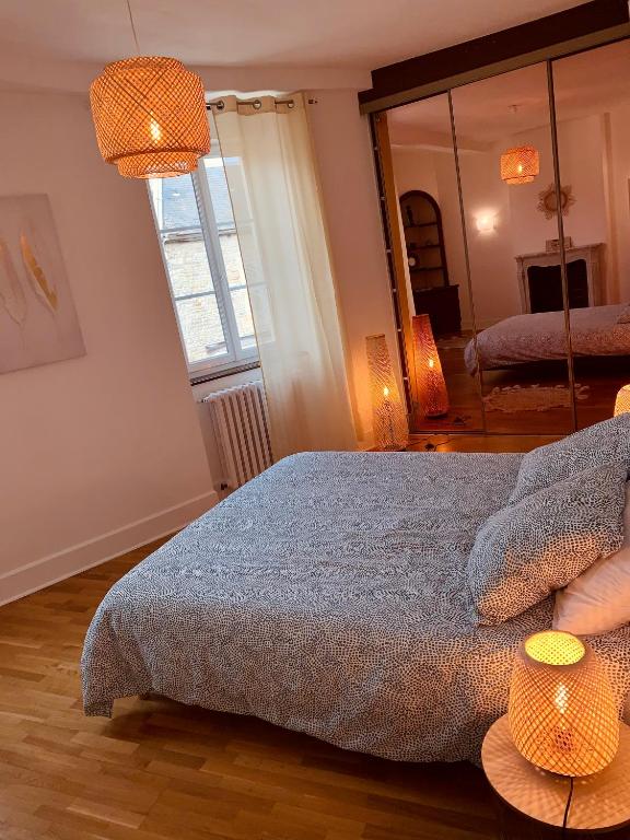 sypialnia z łóżkiem z 2 lampami i lustrem w obiekcie Maison entière aux portes du canal de Bourgogne w mieście Pouilly-en-Auxois