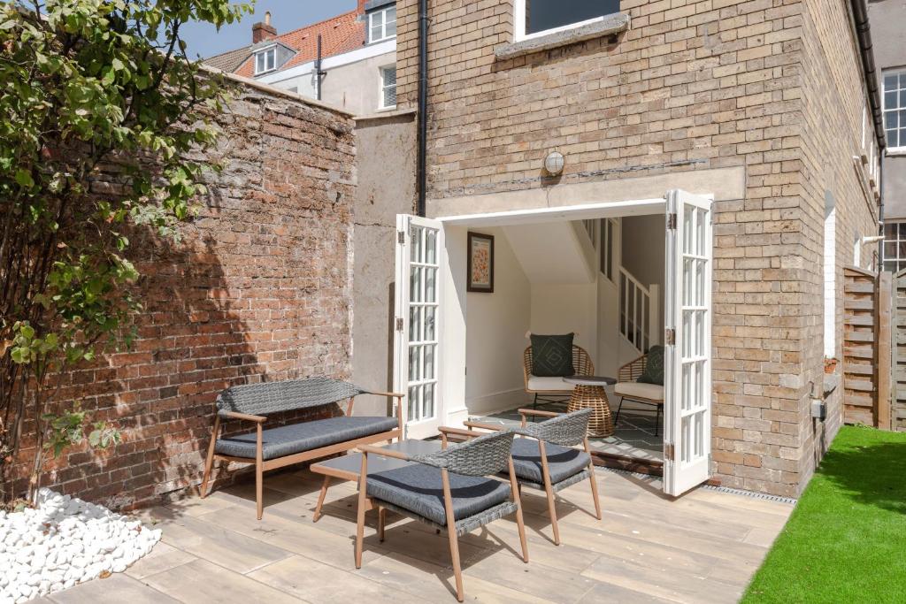 a patio with chairs and tables and a brick wall at Redcliffe Parade No.9 I Your Apartment in Bristol