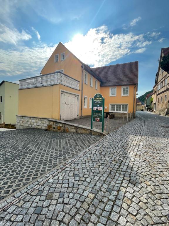 ein Gebäude in einer Kopfsteinpflasterstraße vor einem Haus in der Unterkunft Ferienwohnung Keil in Bad Schandau