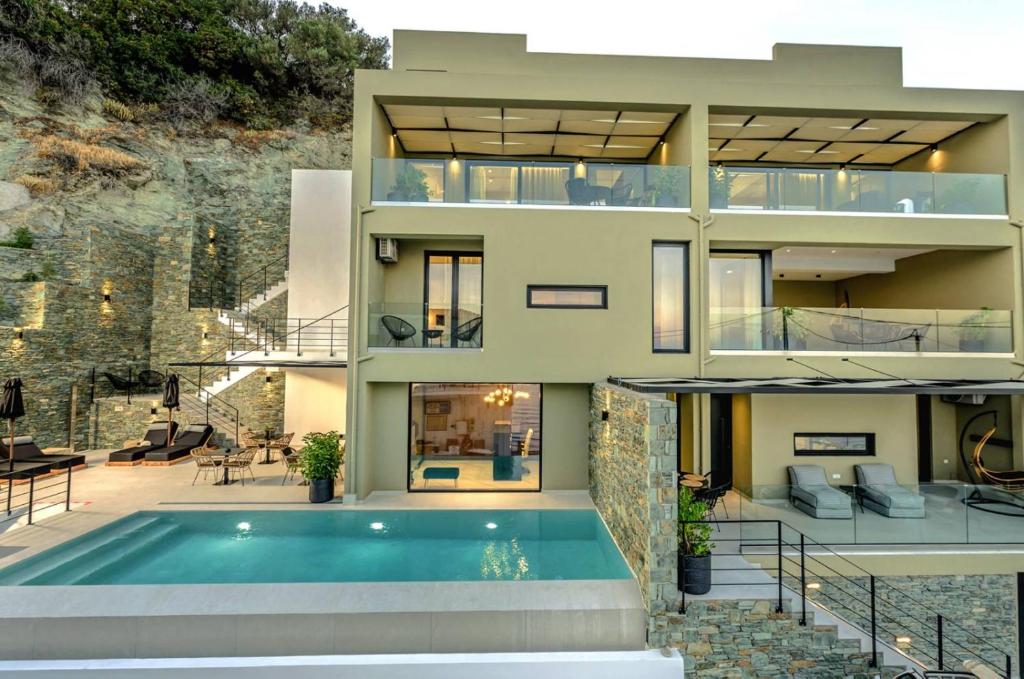 uma casa com uma piscina em frente em Irini Design Apartments em Plomarion