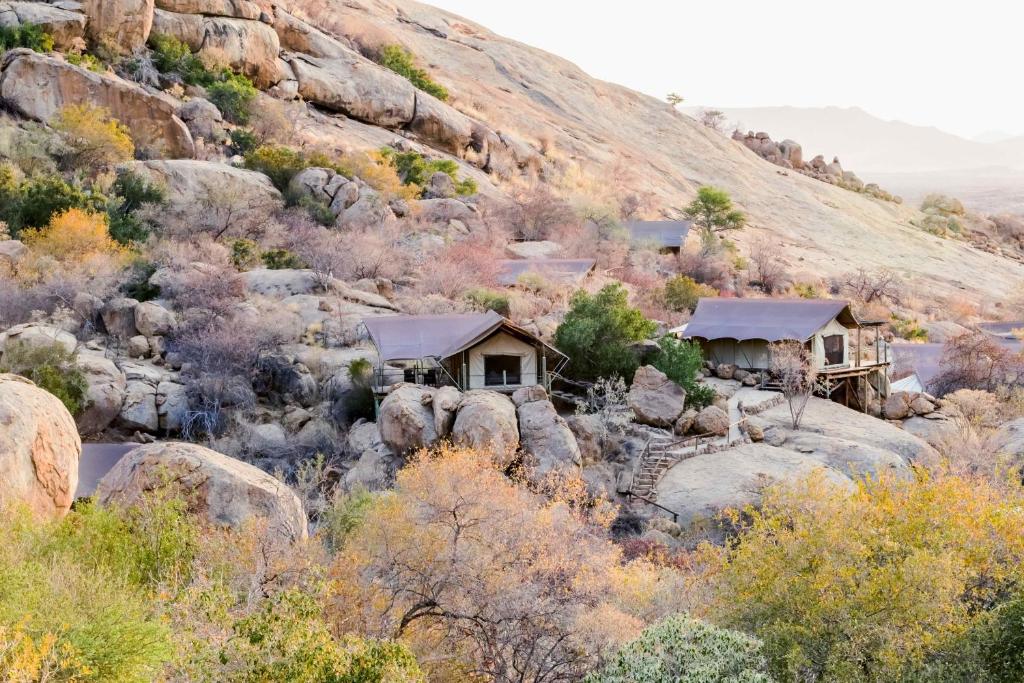 a group of cottages on a rocky mountain at Ondudu Safari Lodge in Omaruru