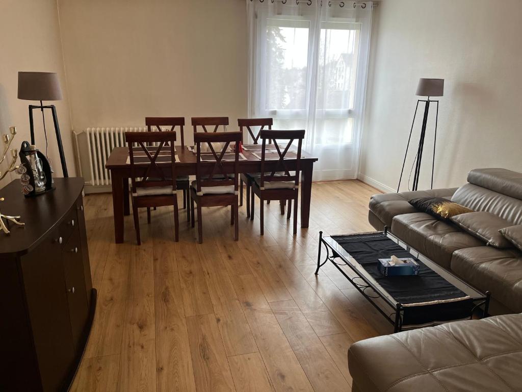 a living room with a table and chairs and a couch at Chambre d hote au calme in Brétigny-sur-Orge