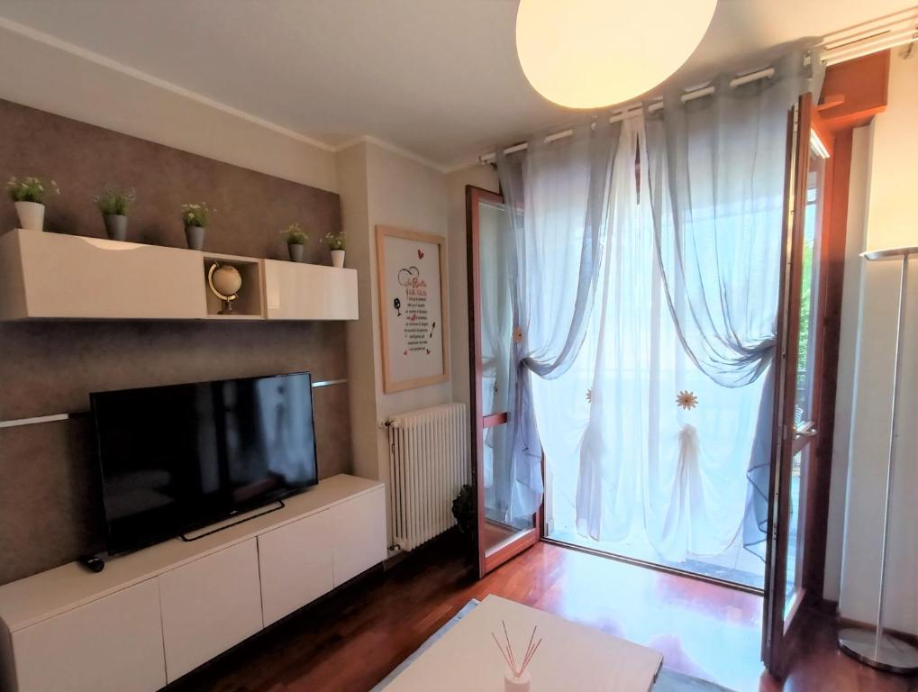 salon z telewizorem i dużym oknem w obiekcie Parco Dora View Apartment w Turynie