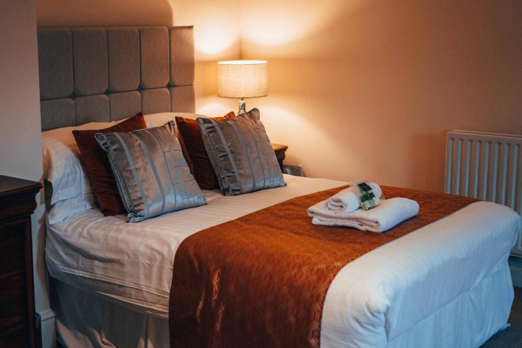 a hotel room with a bed with a towel on it at The Trewythen in Llanidloes