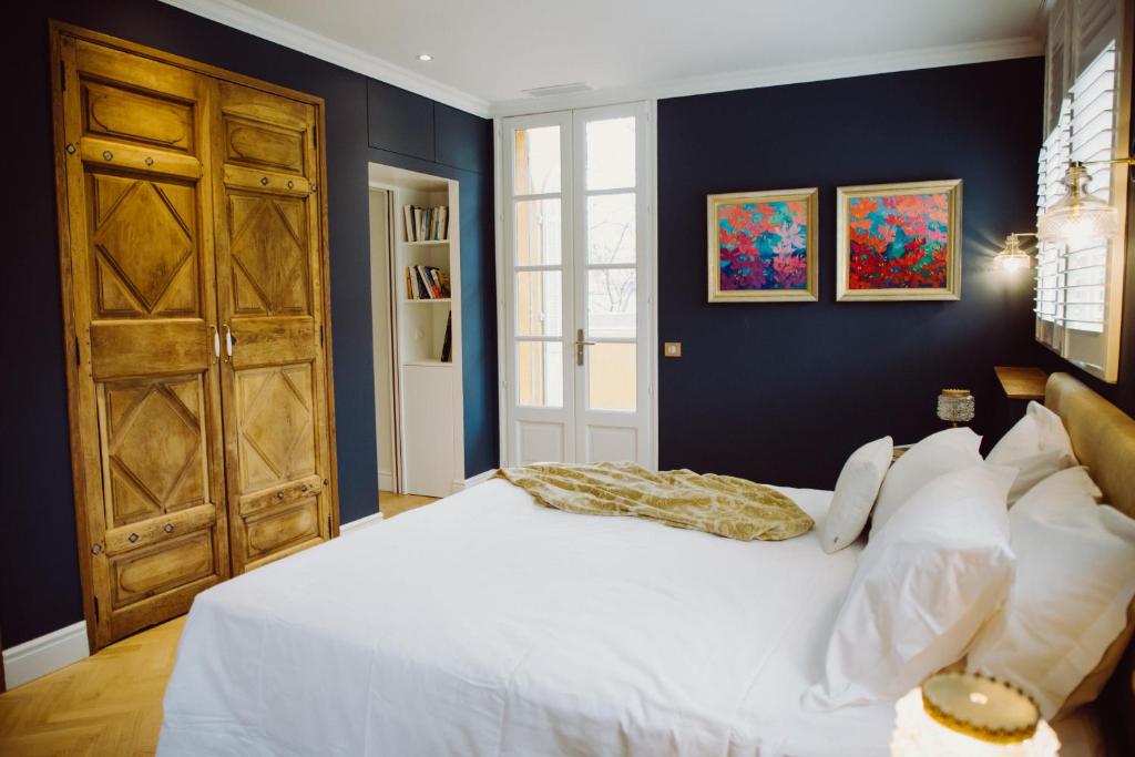 a bedroom with a white bed and blue walls at Villa Amara in Aix-en-Provence