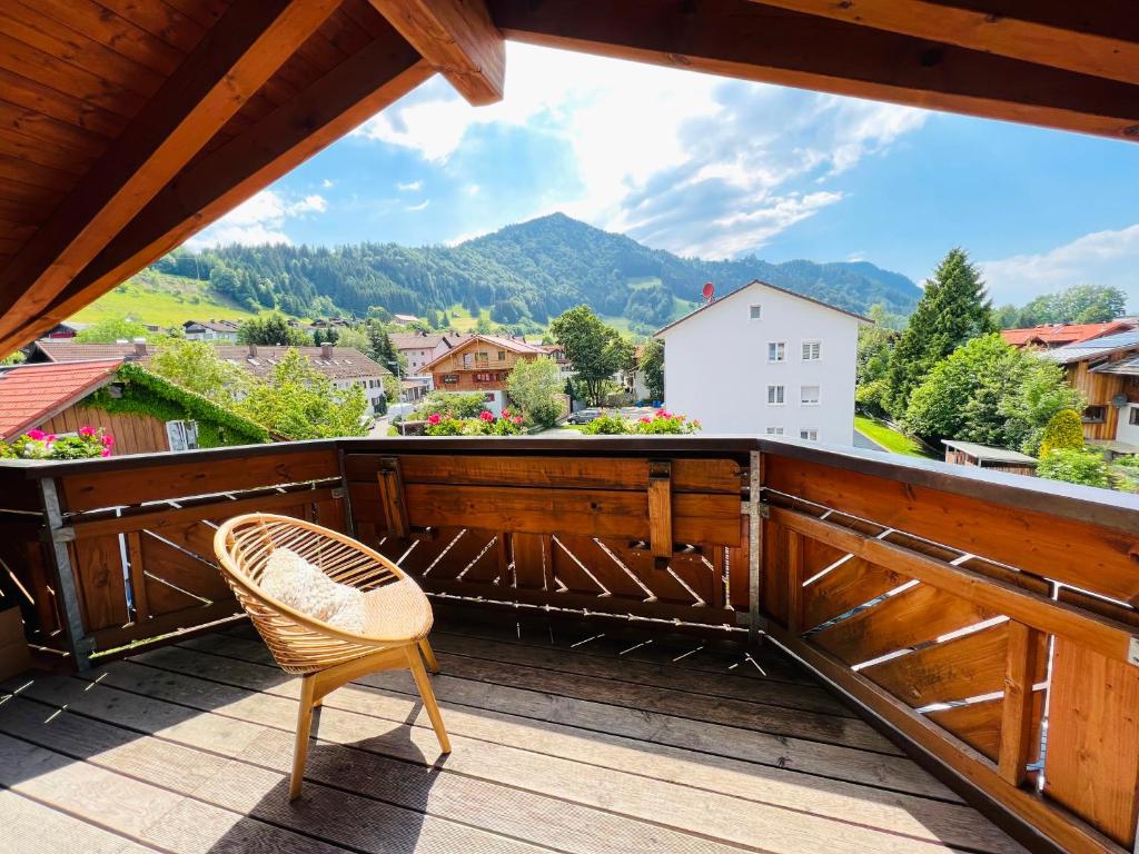a chair on a deck with a view of a mountain at Allgäu SPA House in Blaichach