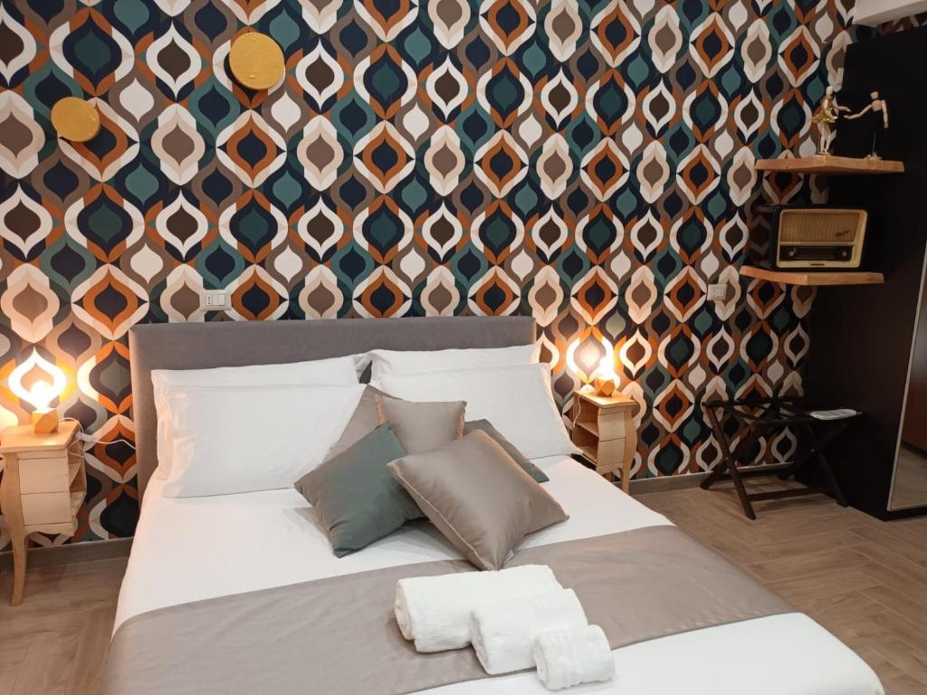 a bedroom with a large bed with pillows and a wall at Geometric Art Home in Bari