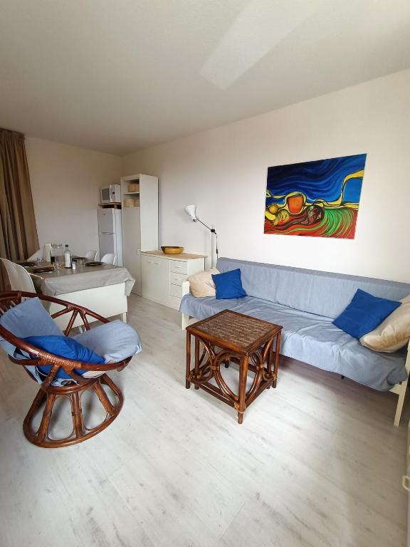 un salon avec un canapé bleu et une table dans l'établissement Appartement avec Piscine et Tennis St Pierre La Mer - 4TMED207I, à Saint Pierre La Mer