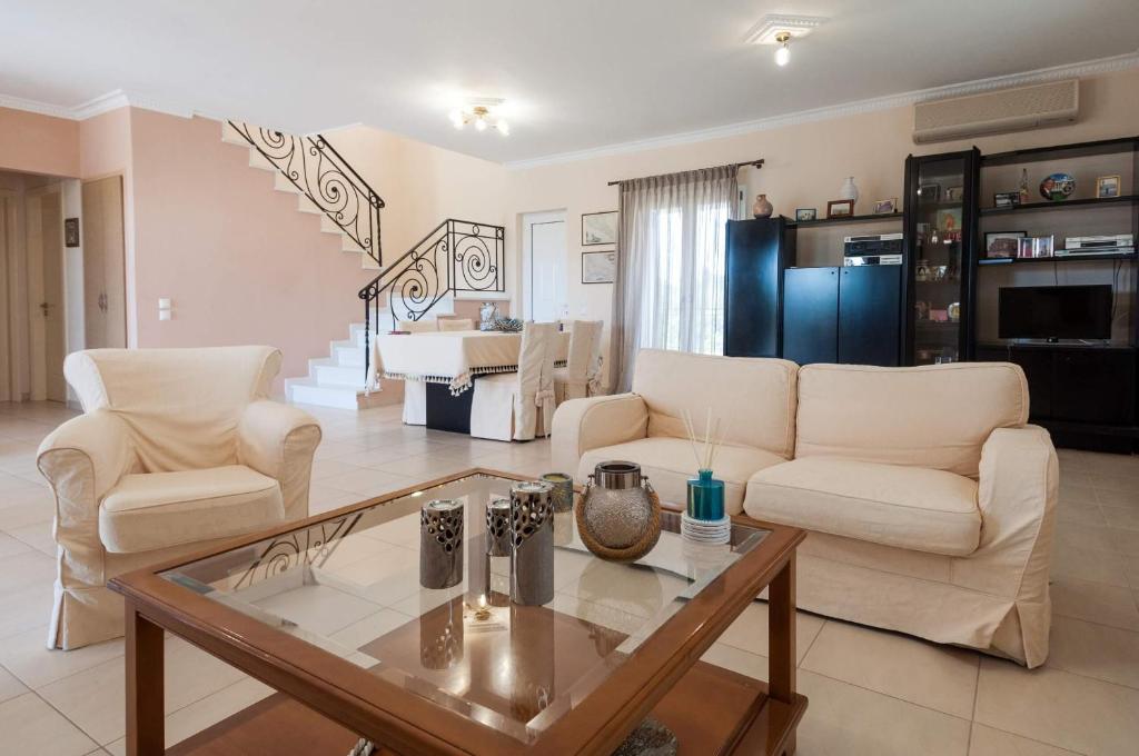 a living room with two white couches and a coffee table at Casa Armonia Zakynthos: 2-Floor Residence in Gaïtánion