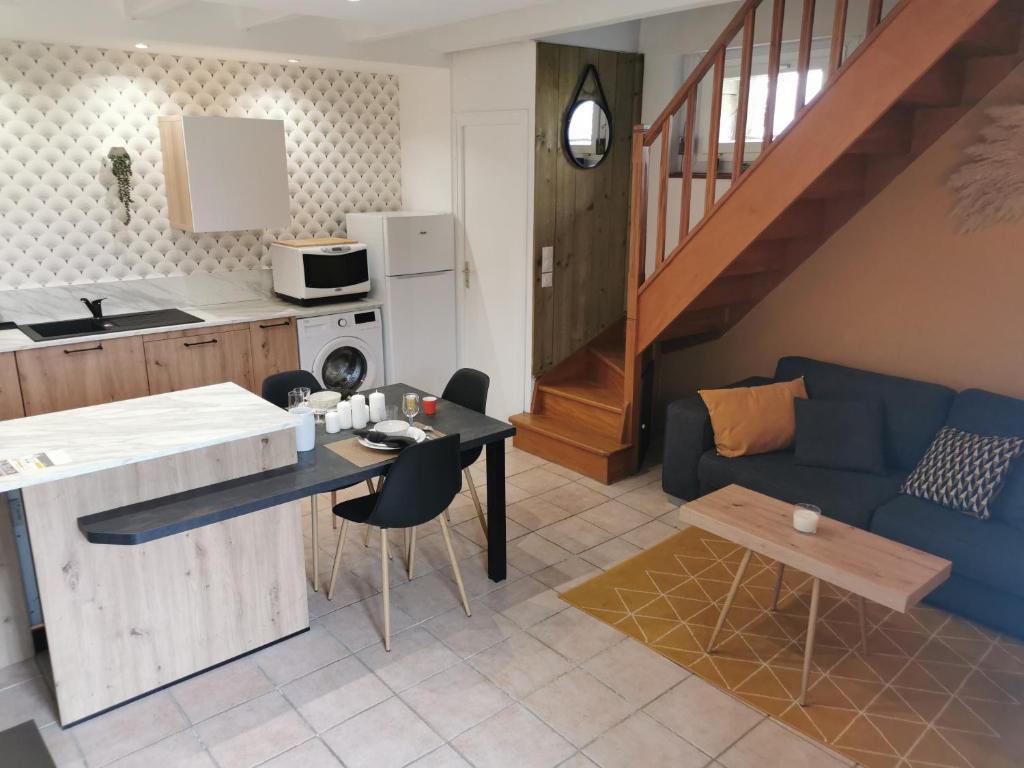 eine Küche und ein Wohnzimmer mit einem blauen Sofa in der Unterkunft Gîte entre Terre et Mer axe Rennes / Saint Malo in Langouet