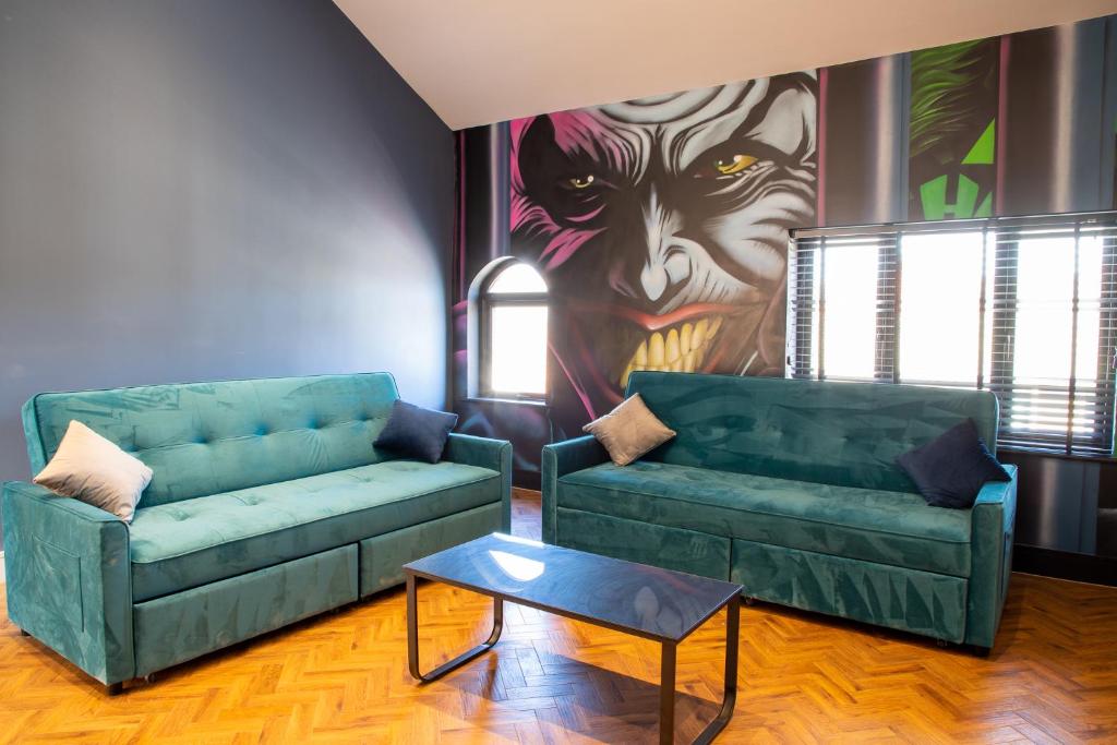 a living room with two green couches and a painting at Withnell Stays - Apartment Six in Blackpool