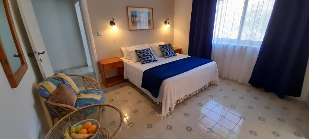 a bedroom with a bed and a chair and a window at Villa Bronja Studio airconditioned apartment Xlendi in Xlendi