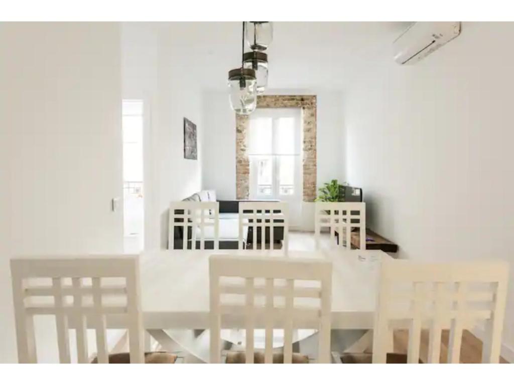 a white dining room with a white table and chairs at Apartamento 3 Habs enfrente de Atocha Mendez3º in Madrid