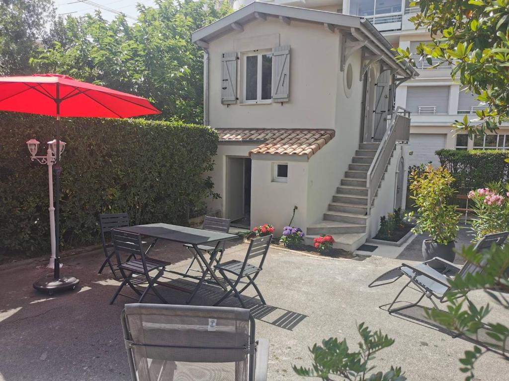 stół i krzesła z parasolem przed domem w obiekcie Studio refait à neuf, 21m², 3 pers., jardin privatif, plage et commerces à proximité, parking inclus - FR-1-433-94 w Arcachon