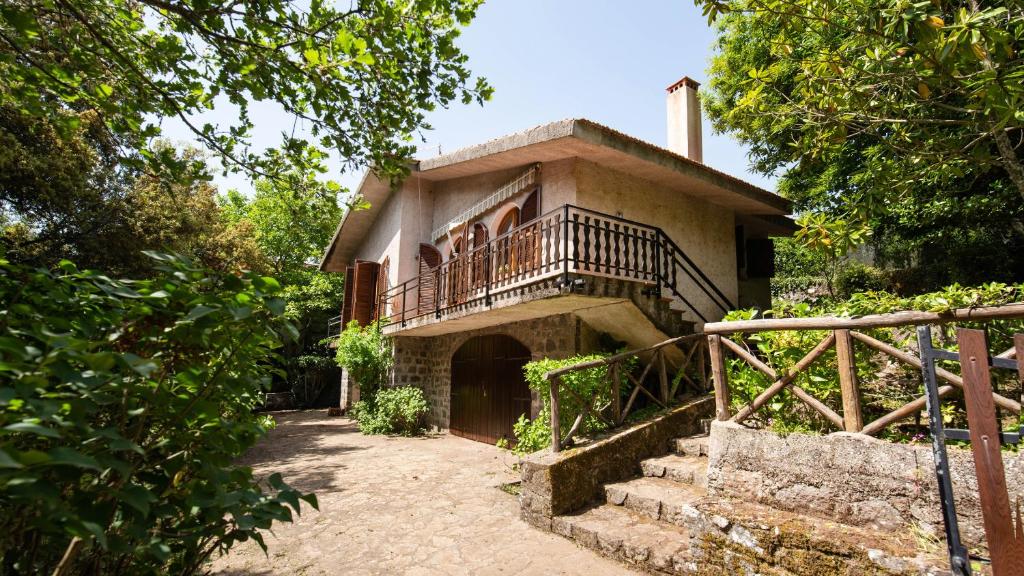 een huis met een balkon en een trap ervoor bij Welcomely - La Casa Delle Querce San Leonardo de Siete Fuentes in Santu Lussurgiu