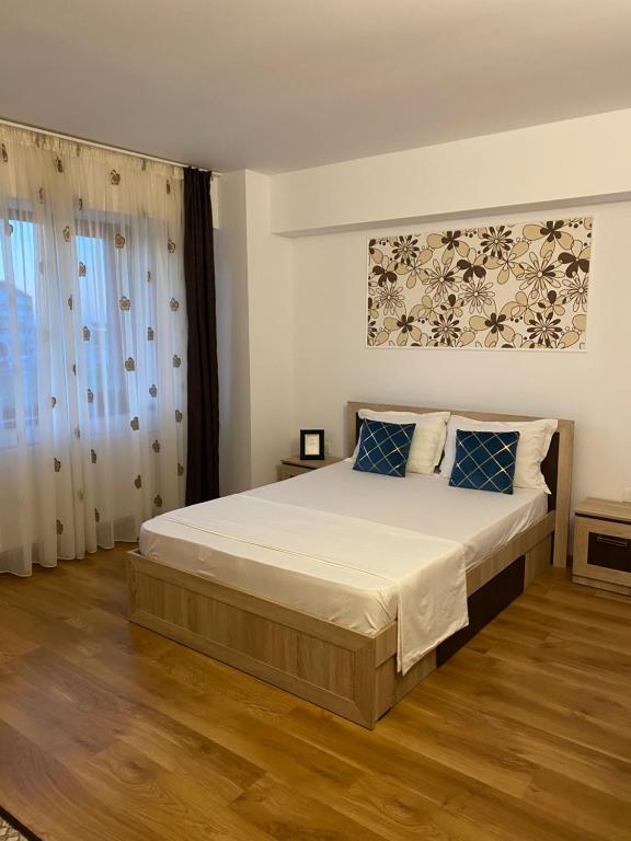 a bedroom with a large bed with blue pillows at Vila Hestia in Constanţa