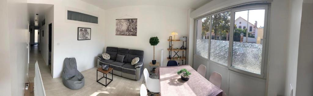 uma sala de estar com um sofá e uma mesa em Chambre privée face à la gare em Tarbes