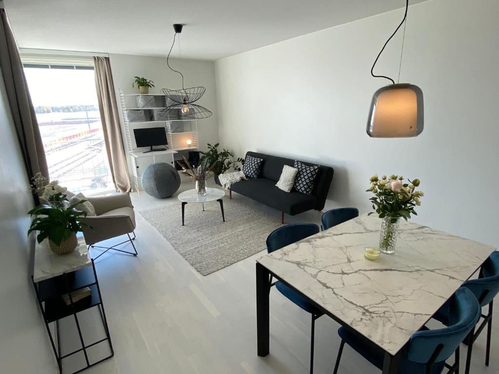 a living room with a table and a couch at Luxury 1-bedroom apartment with sauna and sea view in Helsinki
