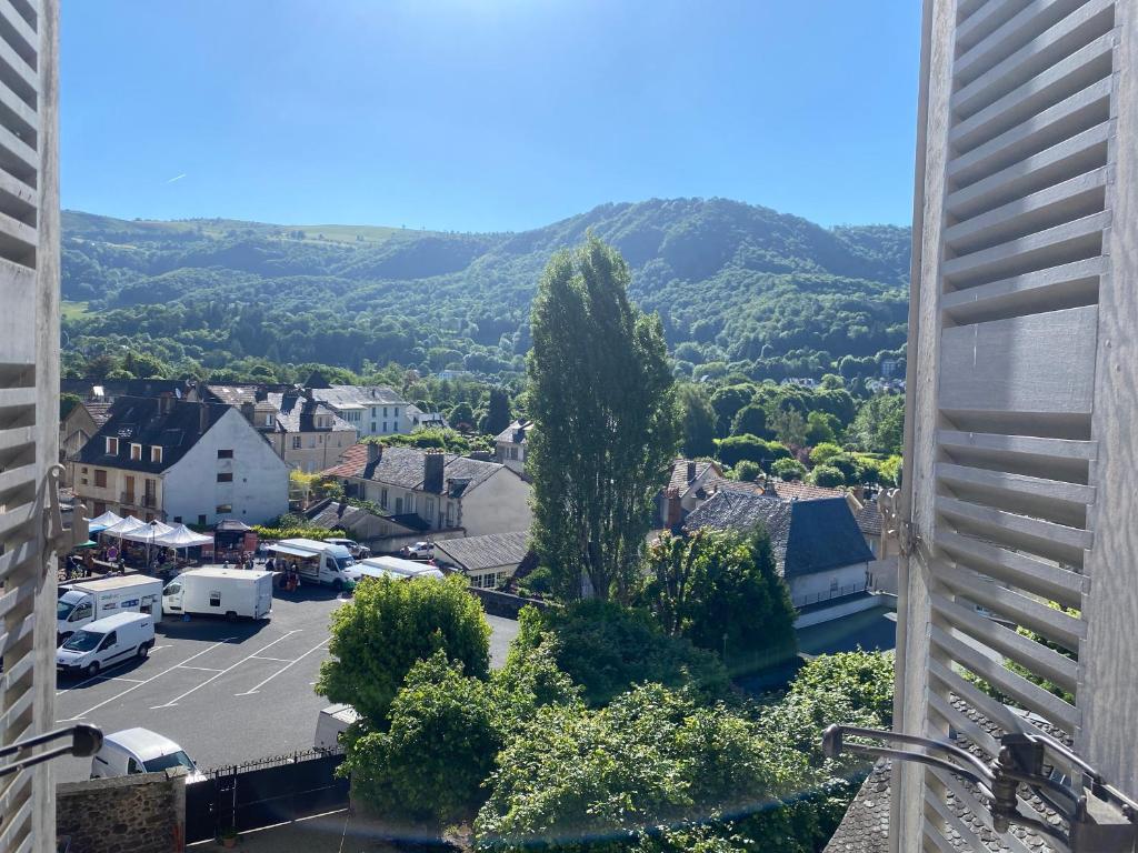 a view of a town with a parking lot and mountains at HOME LE SOFT Vic sur Cère in Vic-sur-Cère