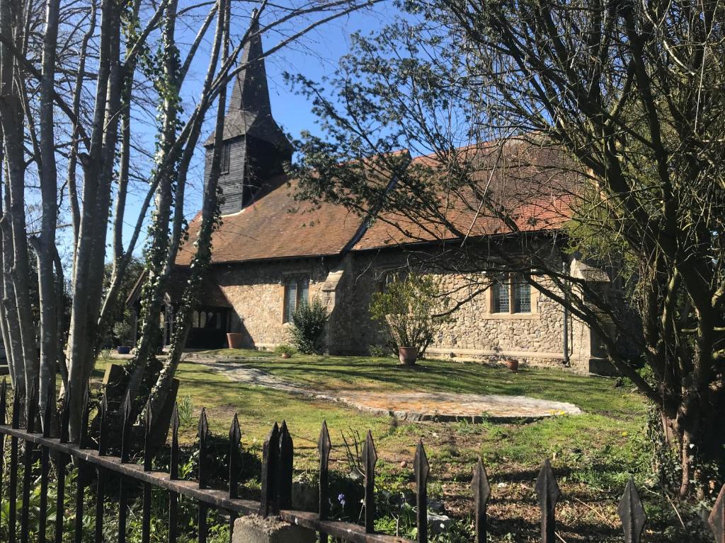 uma velha igreja de pedra com uma cerca em frente em Beautiful grade II listed 4 bed Victorian Conversion - Billericay Essex em Billericay