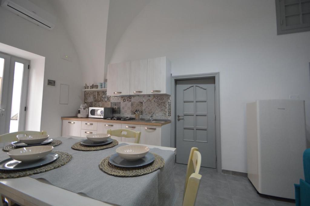 uma cozinha com uma mesa com tigelas e pratos em Casa giulia em Ostuni