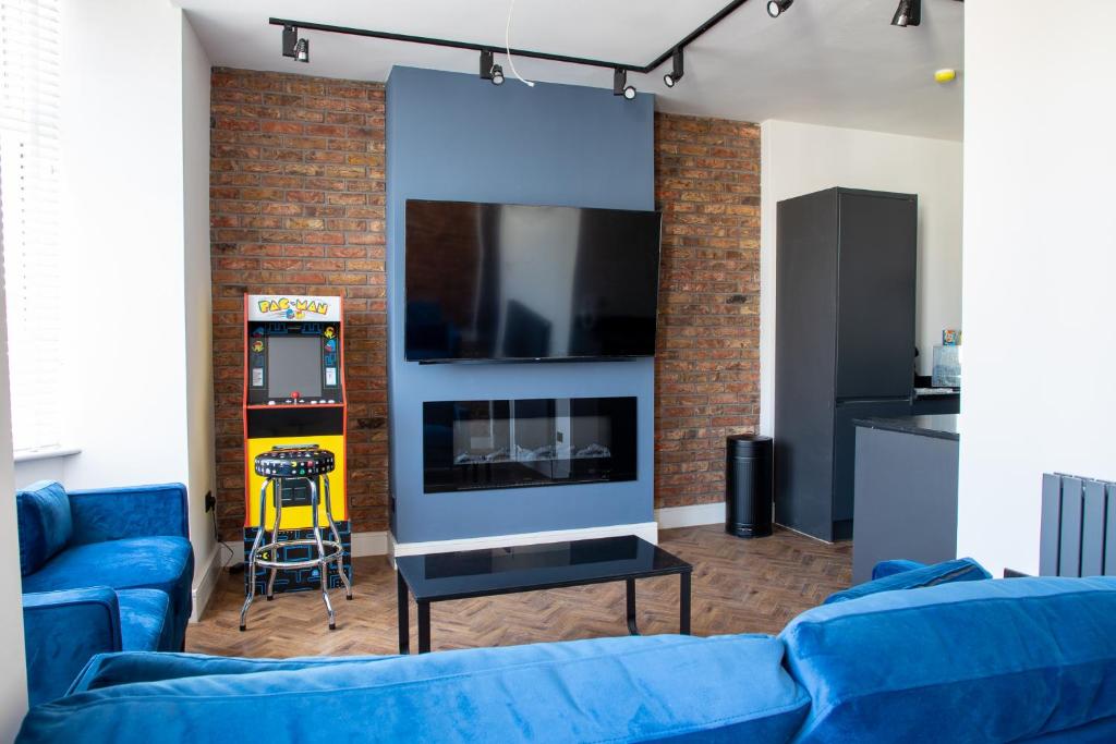 a living room with a blue couch and a tv at Withnell Stays - Apartment Five in Blackpool