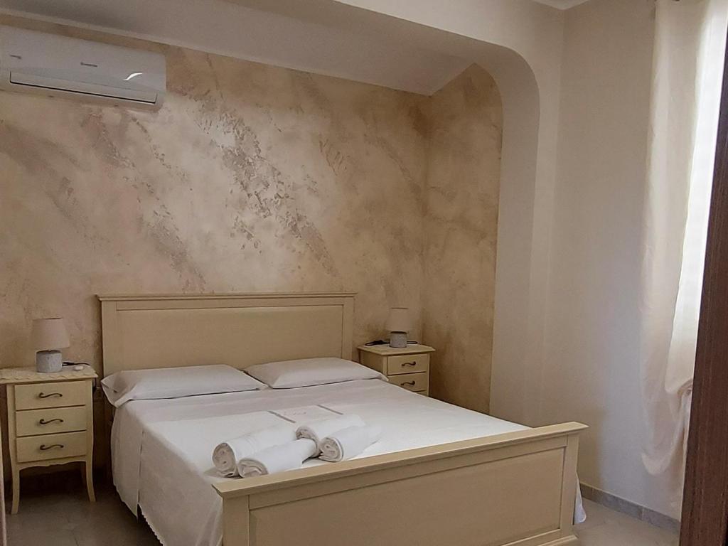 una camera da letto con un letto e due asciugamani di LA PERGOLA a Lampedusa