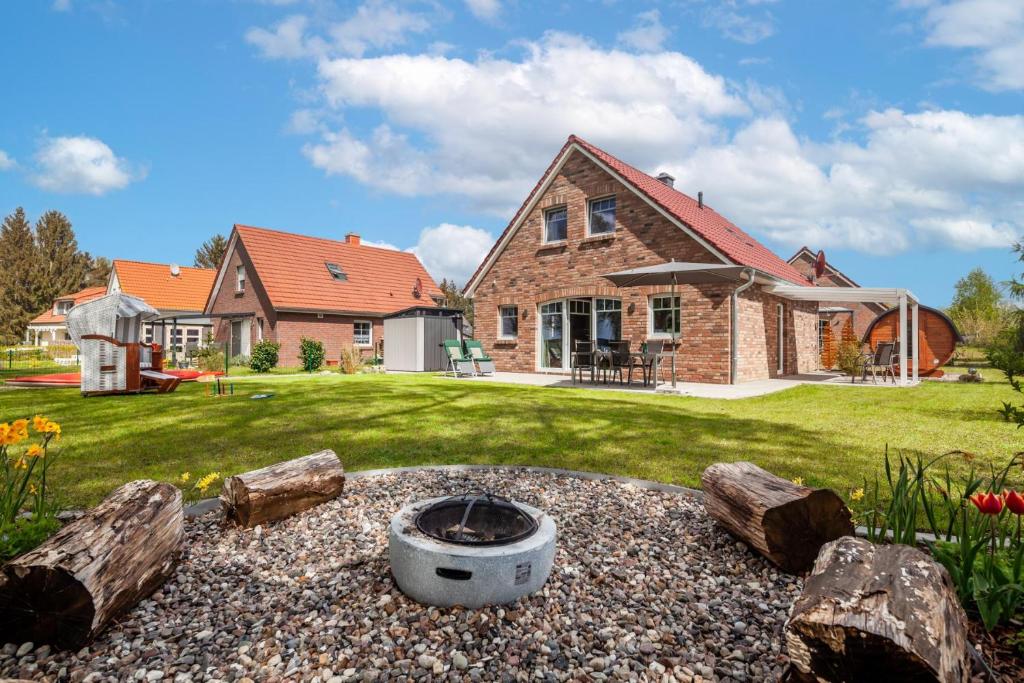 a backyard with a fire pit and a house at Seeblick Warin in Warin