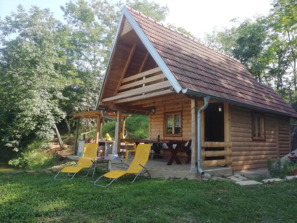 a cabin with a picnic table and chairs in the yard at Vlajina brvnara in Arandjelovac