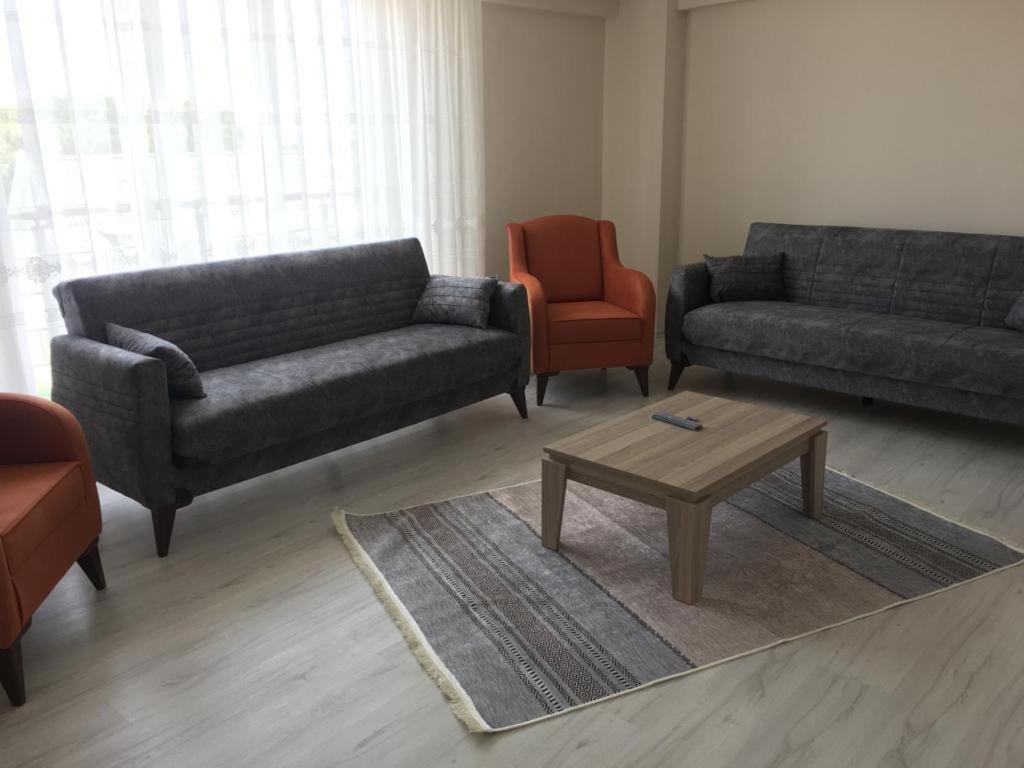 a living room with two couches and a coffee table at Geyikli Lotus Apart in Çanakkale