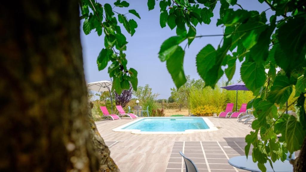 a swimming pool in a yard with pink chairs at Dimore Tarantini in Polignano a Mare