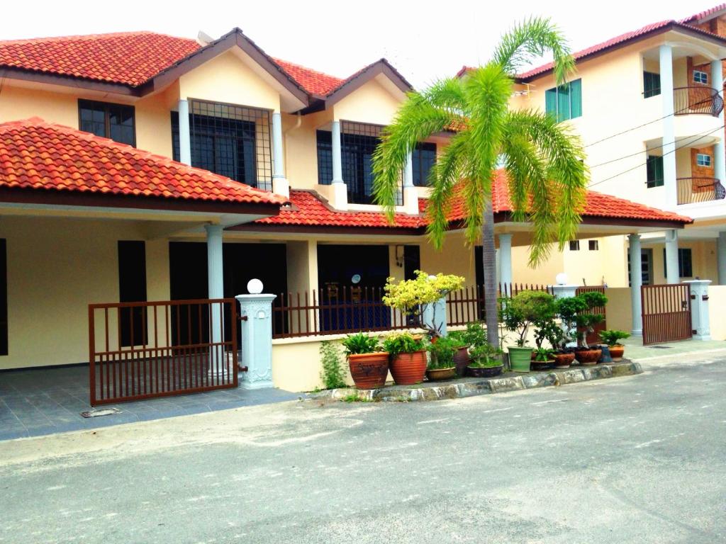 a house with a palm tree in front of it at D'View Guest Houses in Kuala Perlis