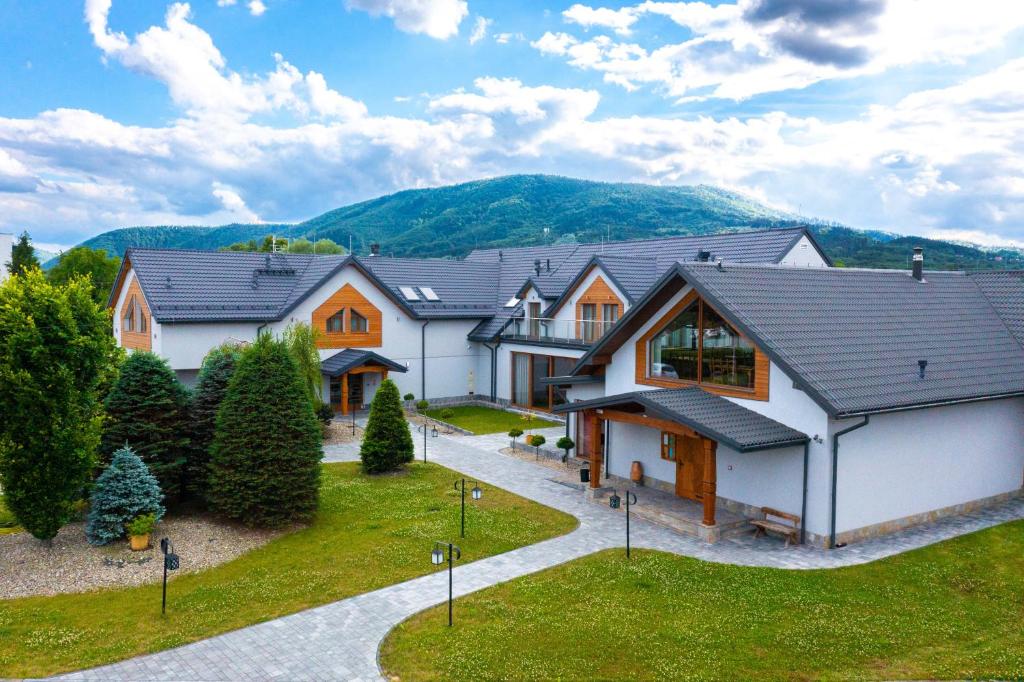 a house with a mountain in the background at Villa & Gospoda Krakowska in Kobiernice