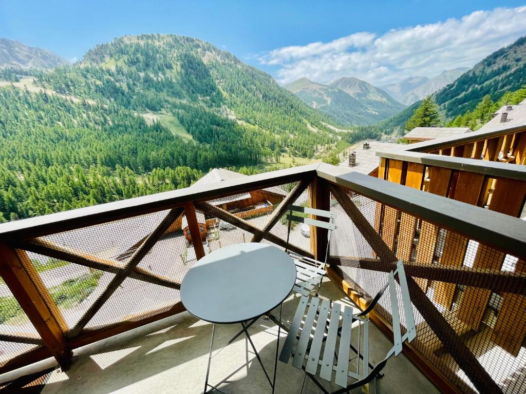uma varanda com mesa, cadeiras e montanhas em T2 avec balcon pour 5 personnes em Isola 2000