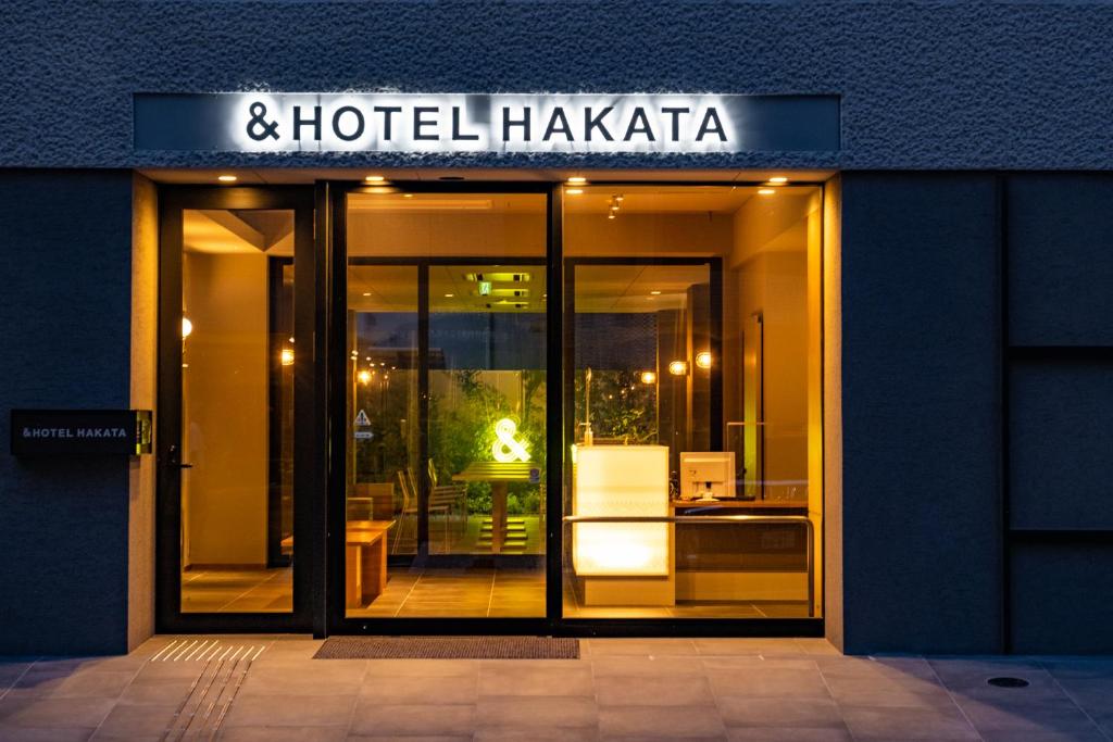 a store front of a hotel had a sign on it at &HOTEL HAKATA in Fukuoka