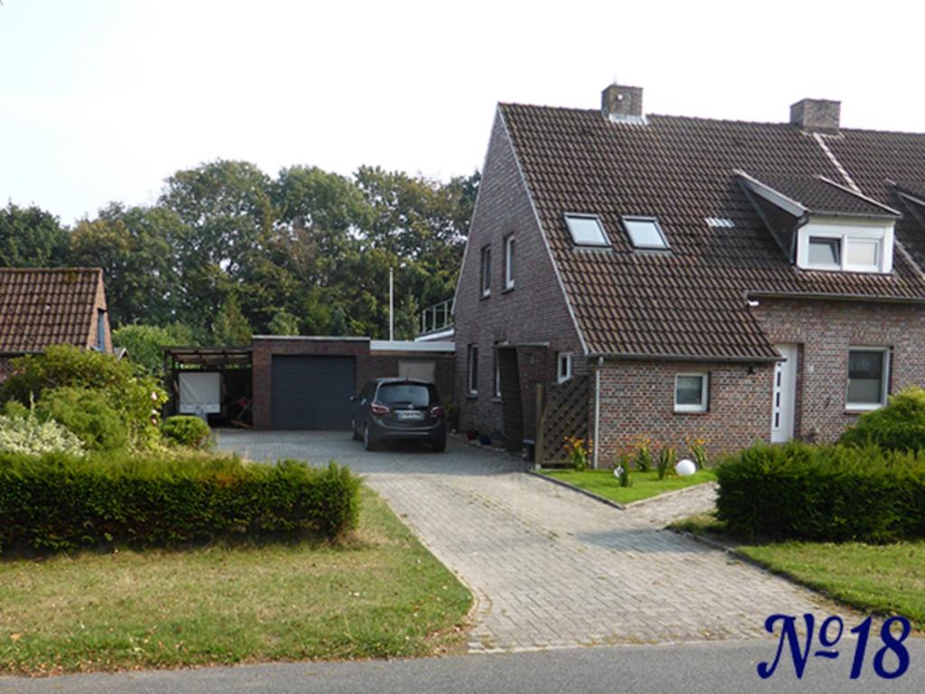 a house with a car parked in the driveway at Ferienwohnung Gerhards in Esens