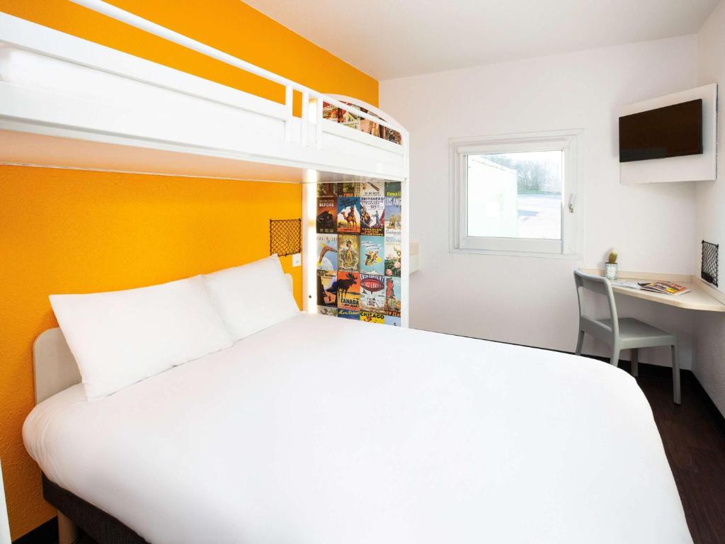 een slaapkamer met een groot wit bed en een bureau bij hotelF1 Orange Centre Echangeur A7 A9 in Orange