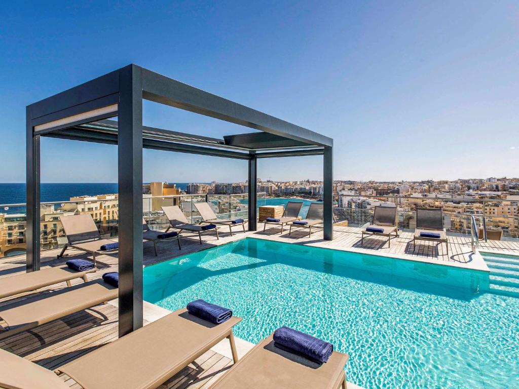 a swimming pool on the roof of a building at Mercure St. Julian's Malta in St Julian's