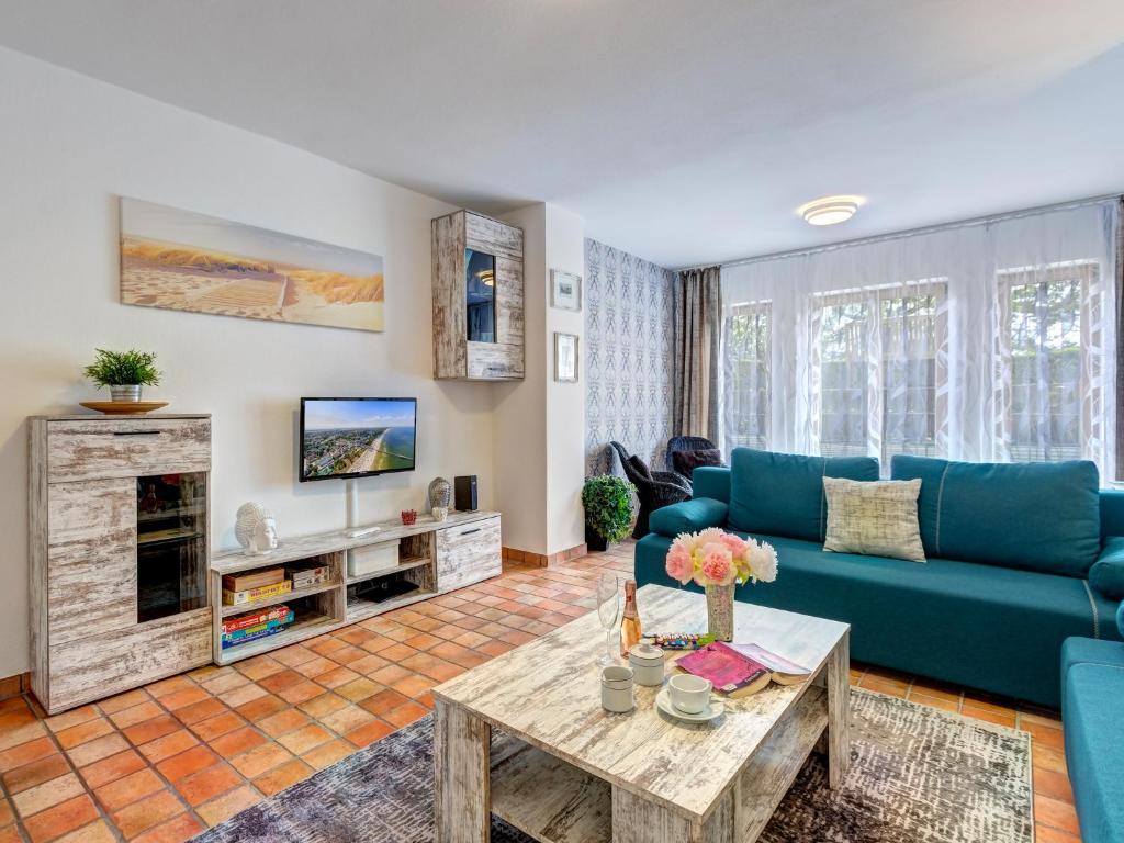 a living room with a blue couch and a table at FeWo Tusculum in Zinnowitz