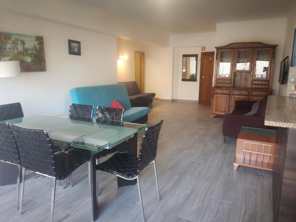 - un salon avec une table, des chaises et un canapé dans l'établissement Safira Vista Mar Apartment, à Portimão