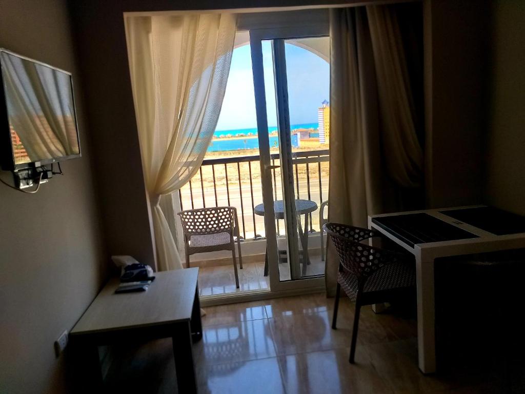 een kamer met een balkon met uitzicht op de oceaan bij porto marina panoramica sea view in El Alamein
