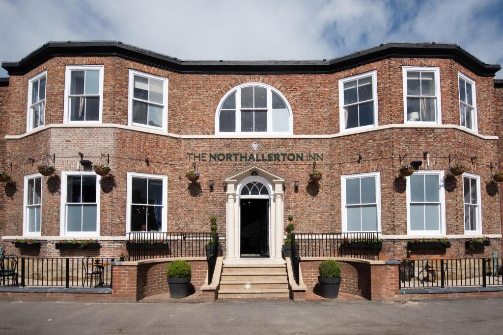 un edificio de ladrillo rojo con un cartel. en The Northallerton Inn - The Inn Collection Group en Northallerton