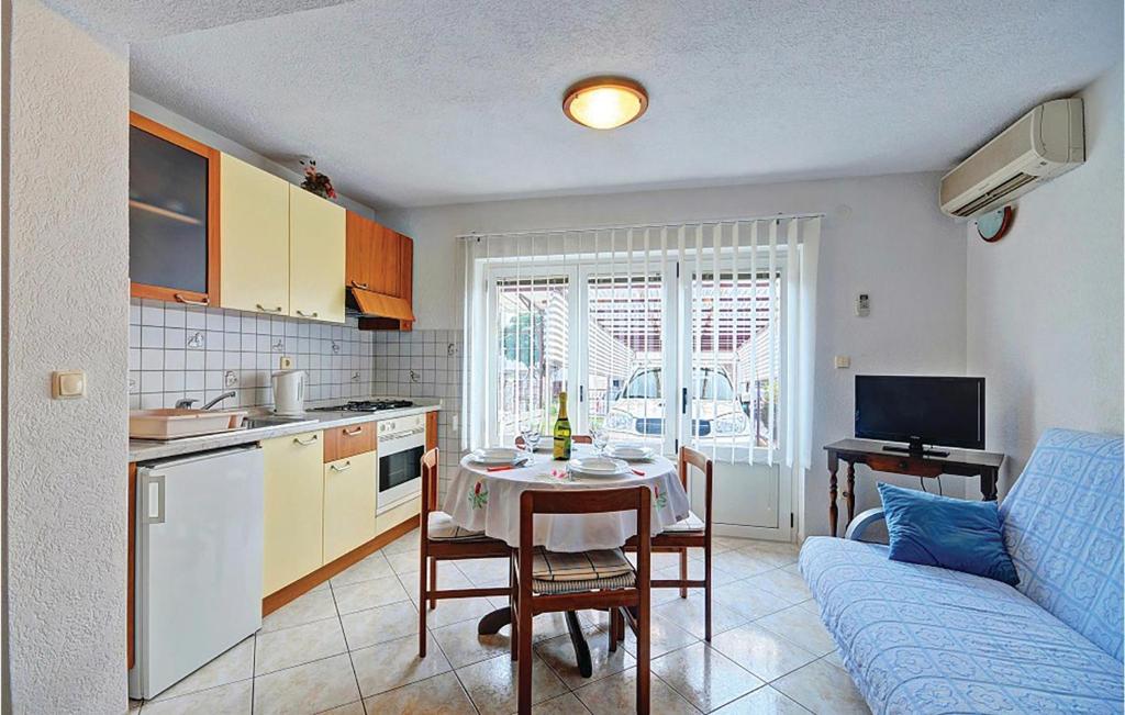 Il comprend une cuisine et un salon avec une table et un canapé. dans l'établissement Beautiful Apartment In Pula With Kitchen, à Pula